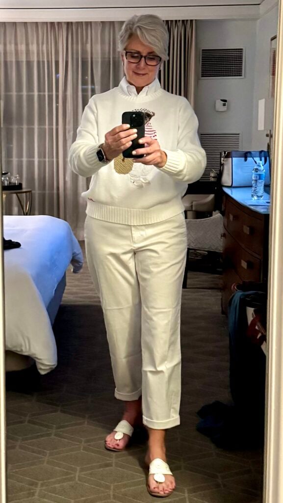 Tonal white outfit over 50 — Polo Bear sweater layered over a white shirt with white chinos.