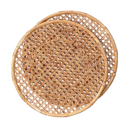 Set of two round rattan charger plates with an intricate woven cane pattern and natural honey-brown finish, perfect for layering under dinnerware for casual summer entertaining.