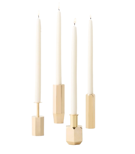 Modern brass taper candle holders with geometric faceted bases, holding white taper candles to create an elegant and contemporary table centerpiece.