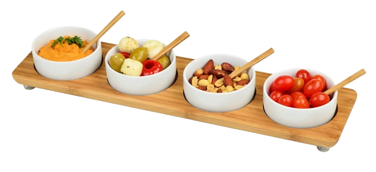 Rectangular bamboo serving tray with four white ceramic bowls and wooden spoons, filled with dips, olives, mixed nuts, and cherry tomatoes for entertaining.