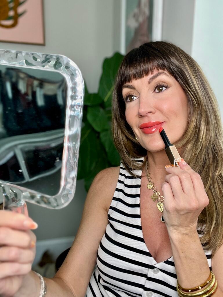 Jennifer beauty editor for Style at a Certain Age applying summer lip colors over 50 in a mirror