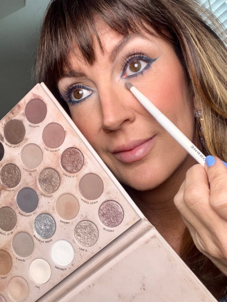 Matte white eyeshadow applied under the brow bone to lift the eye