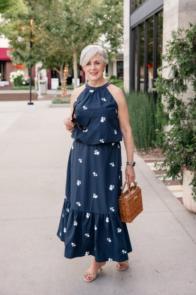 Summer outfit for women over 50 featuring a navy matching set, straw handbag, and nude kitten heels styled by Beth of Style at a Certain Age.