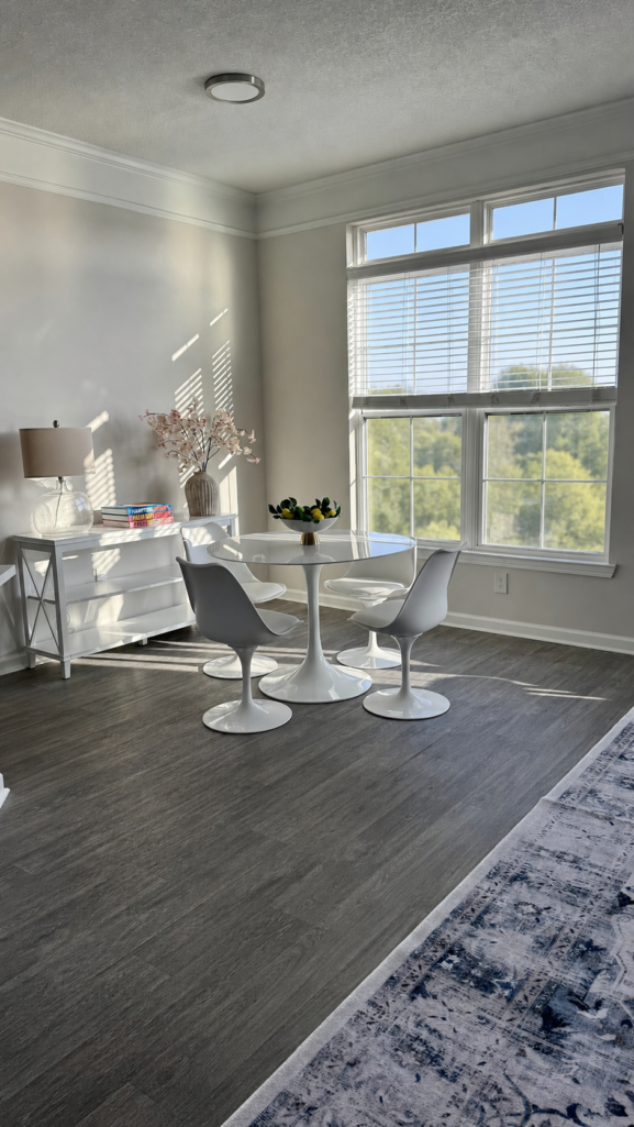 Saarinen-style white tulip dining table with upholstered chairs in a bright Atlanta apartment living space