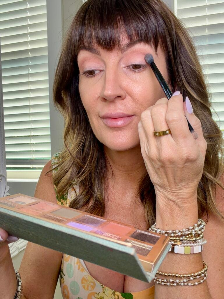applying olive shimmer eyeshadow with fingertip, two-step process