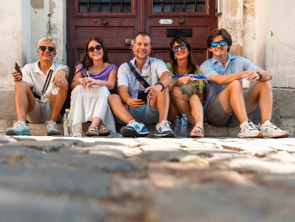 family seated on a European street wearing Frankie4 sandals
