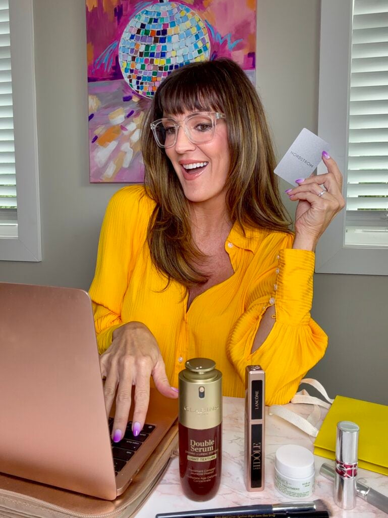 Woman over 50 shopping Nordstrom Anniversary Sale beauty exclusives online at her desk