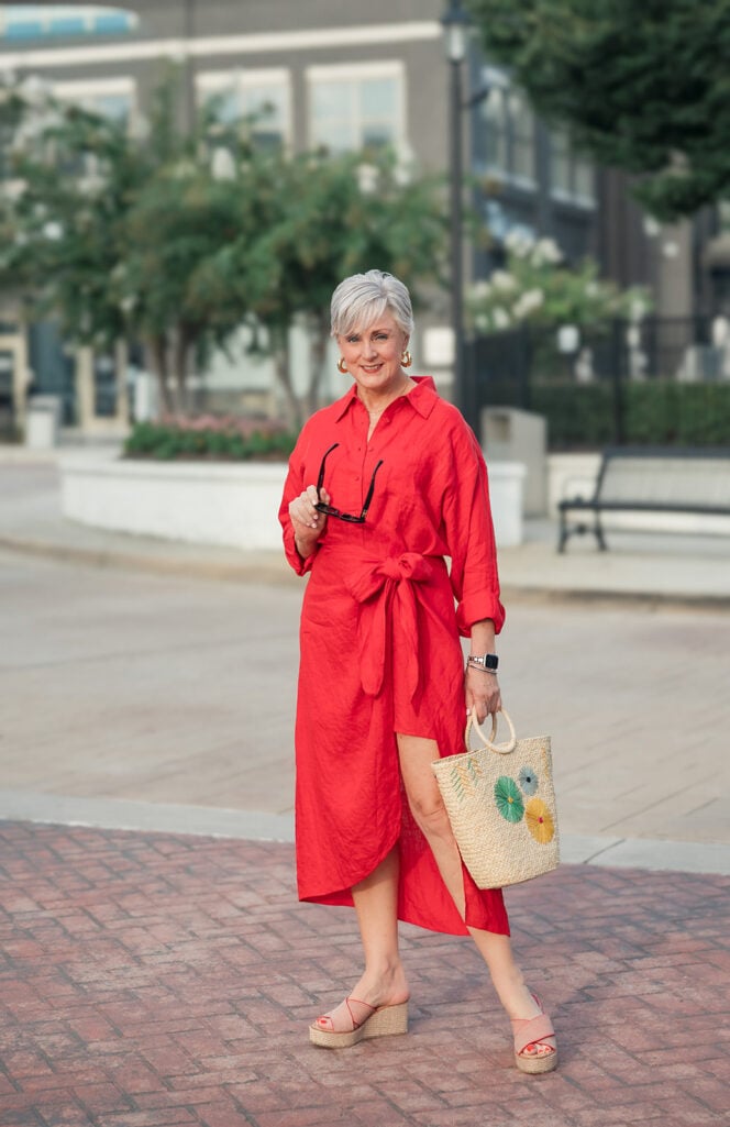 Red linen Apiece Apart shirtdress on a hanger — an easy Friday reunion-weekend outfit for women over 50.