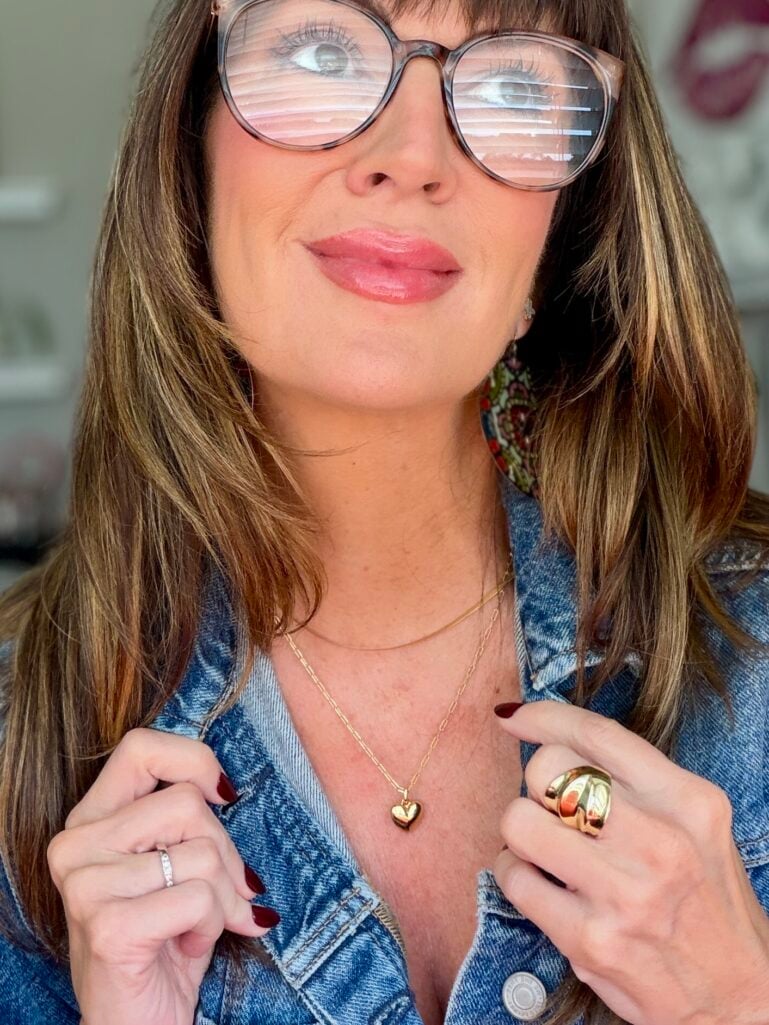 Ana Luisa Lev heart necklace layered on a woman over 50