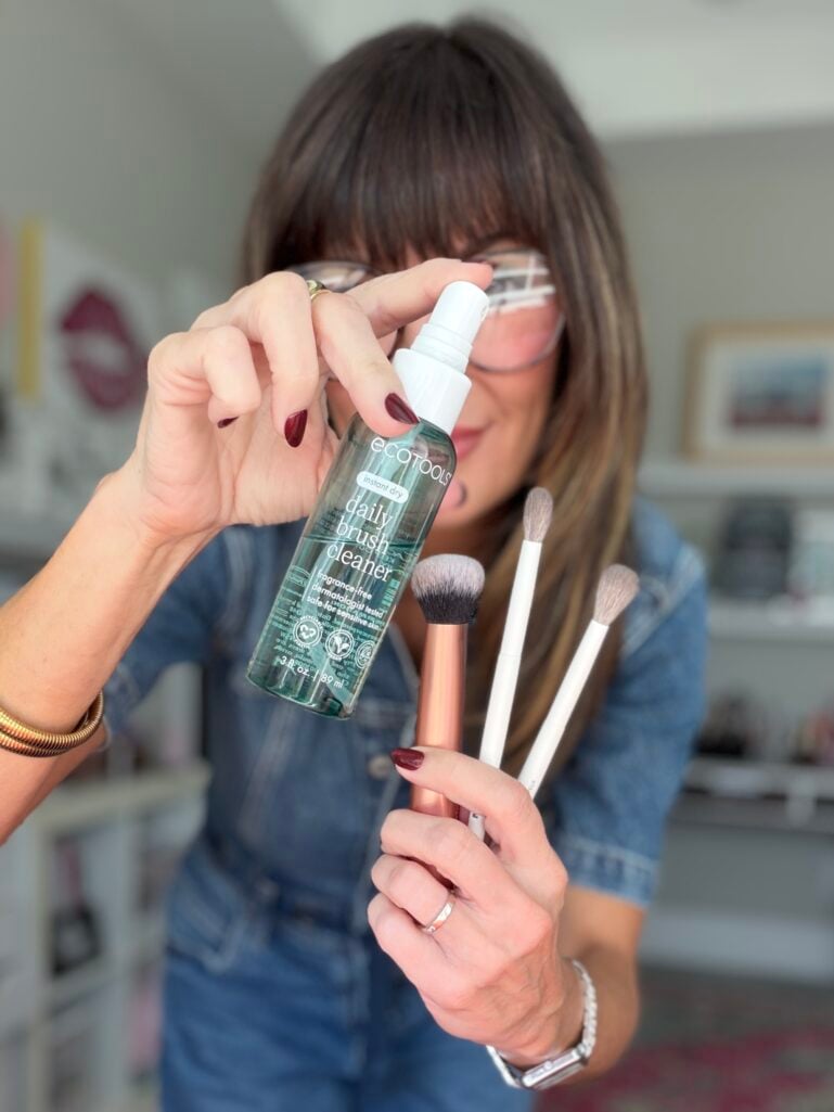 Eco Tools daily makeup brush cleaner bottle held in hand