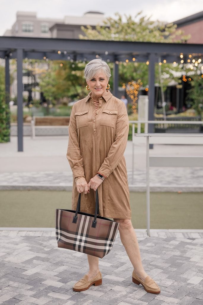 Camel faux suede shirt dress with gold buttons and patch pockets, layered over a rust striped tee and worn with tan suede loafers