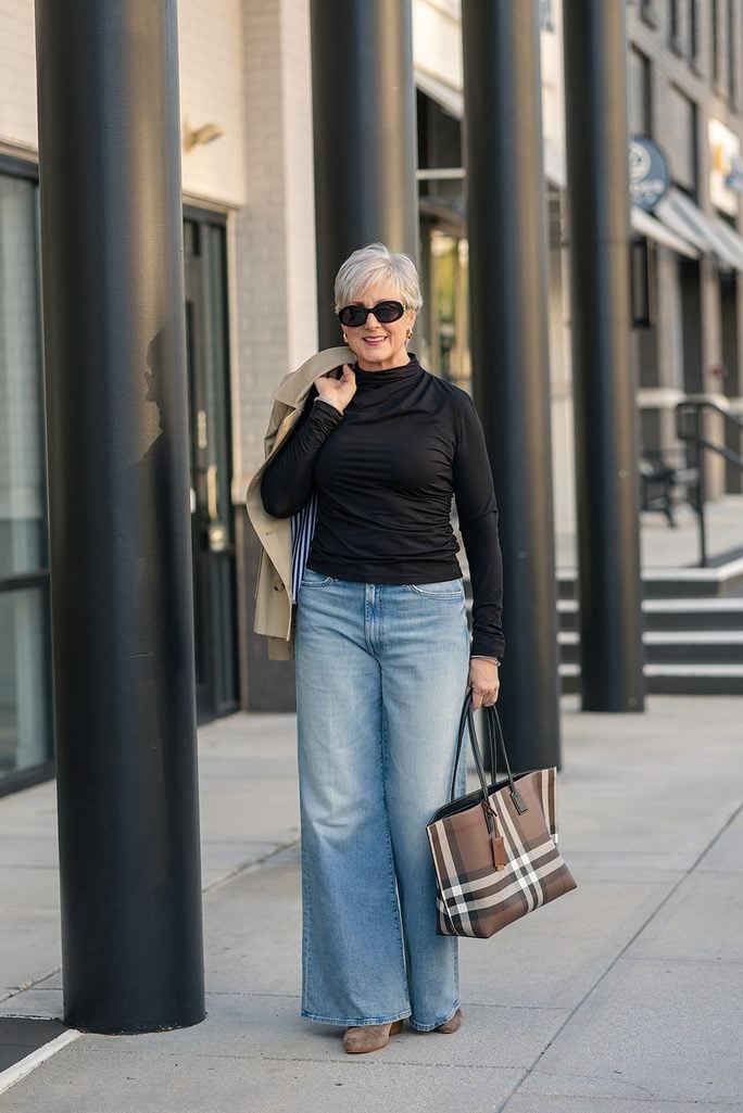 Wide-leg Mother jeans styled with taupe suede booties and a cropped trench coat
