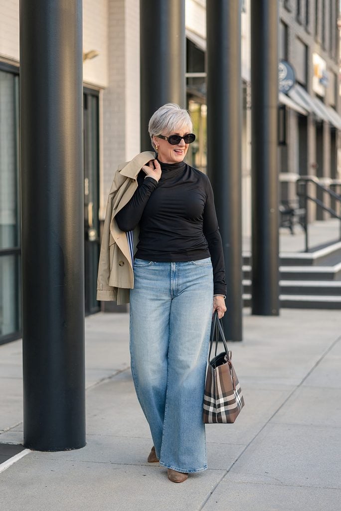 Wide-leg Mother jeans styled with taupe suede booties and a cropped trench coat