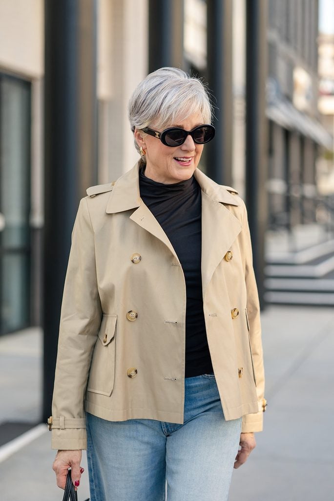 This is where we want a closer look at the jacket itself. The copy is talking about the shorter length and traditional trench details, so the image reinforces the lesson rather than simply decorating the page.