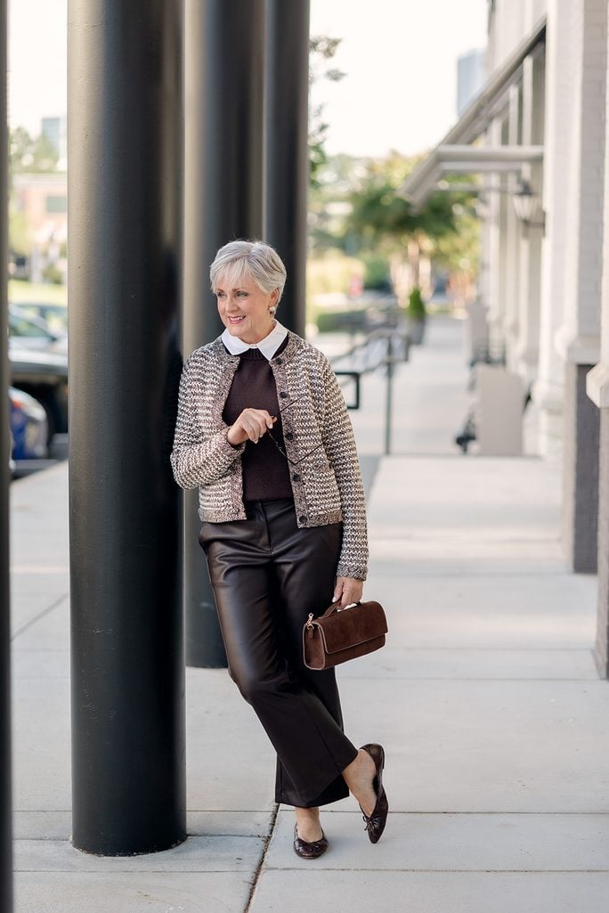 Beth Djalali in a Veronica Beard tweed cardigan, collared sweater tee, faux leather trousers, and snakeprint ballet flats on a city street in Atlanta