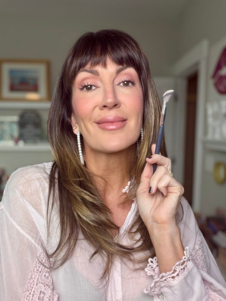Jennifer holding the concealer brush with the finished look