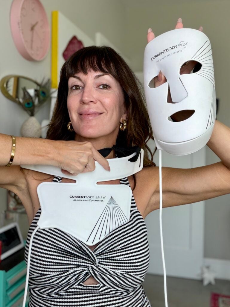 Jennifer Duvall holding up the CurrentBody Skin LED face mask and the LED neck and décolleté perfector