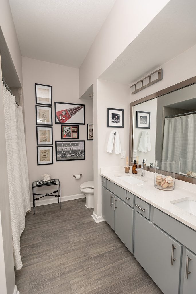 Guest bathroom with a salon-style gallery wall of vintage sports photos, inspired by Ralph Lauren.