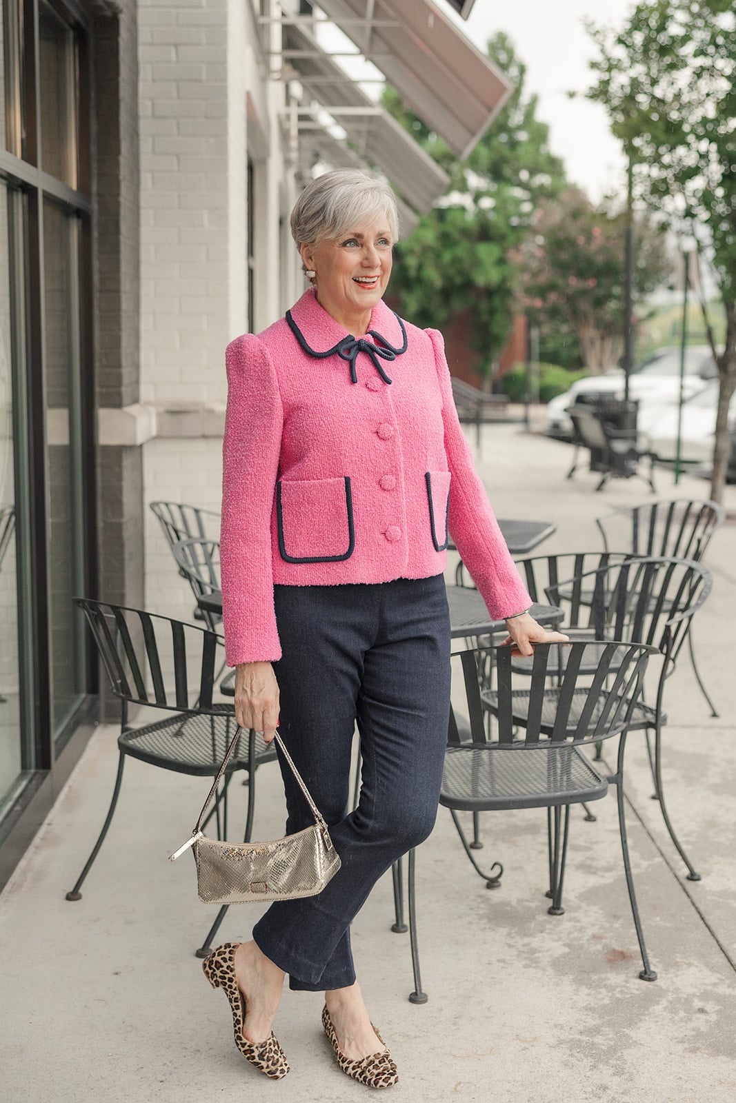 Pink bouclé blazer with navy piping and a bow, worn with cropped flares and leopard shoes