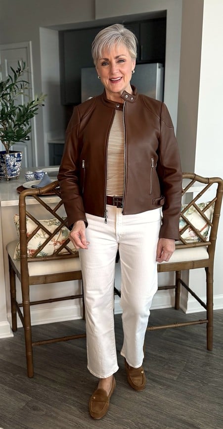 Beth in leather jacket and white jeans