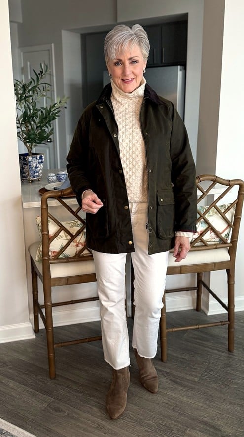 Beth in waxed cotton jacket. fisherman sweater, white jeans, and suede booties