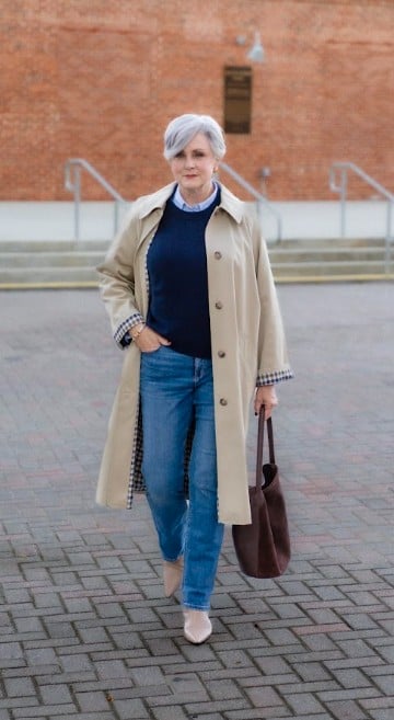 Beth in trench coat, sweater and jeans