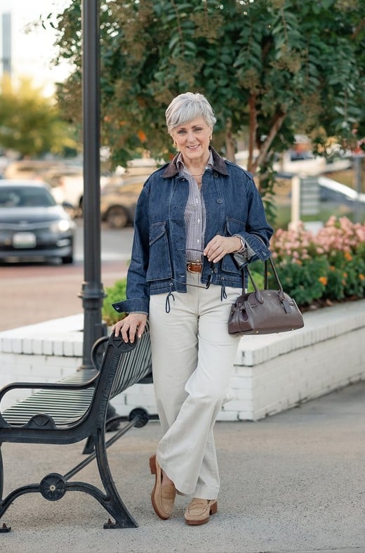 Beth in denim jacket, checked shirt and chino pants