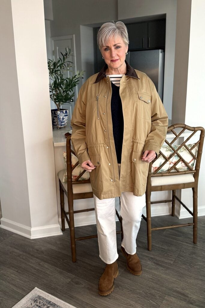 Twill safari jacket over a V-neck sweater and striped tee with white jeans and Chelsea boots